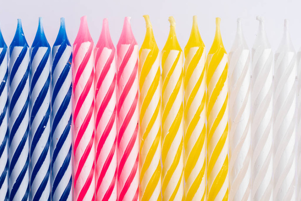 Gros plan avec des bougies d'anniversaire. Position verticale. Très coloré, avec bleu, rouge, jaune et blanc. Pour carte de vœux anniversaire
.. - Photo, image