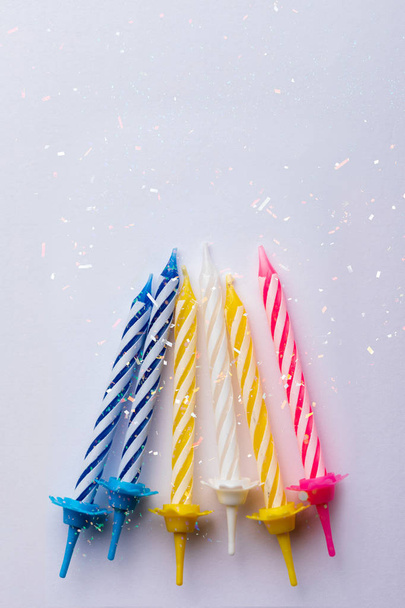Groep verjaardagskaarsen op witte achtergrond. Voor verjaardagskaart. Ruimte om tekst in te voegen. Zeer kleurrijk, met blauw, rood, geel en wit. - Foto, afbeelding