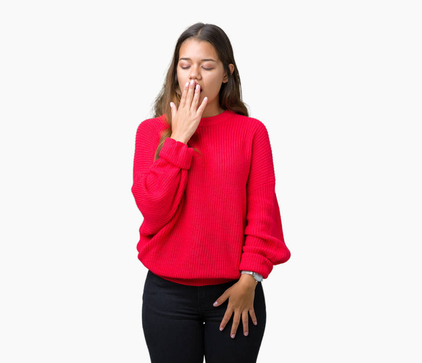 Młoda piękna kobieta brunetka sobie sweter zimowy czerwony na białym tle znudzony ziewanie zmęczony krycia usta ręką. Restless i senność. - Zdjęcie, obraz
