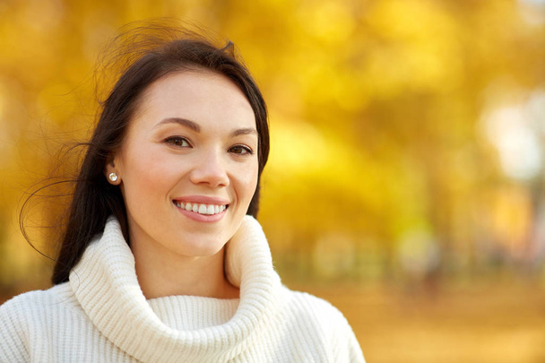 portrait of happy young woman in autumn park - 写真・画像