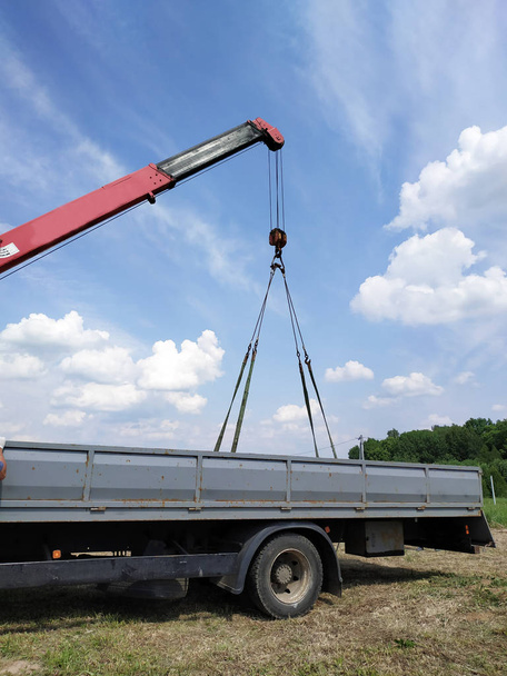The car crane transports the metal profile from the car body. - Photo, Image