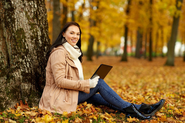 woman with tablet computer at autumn park - Фото, зображення