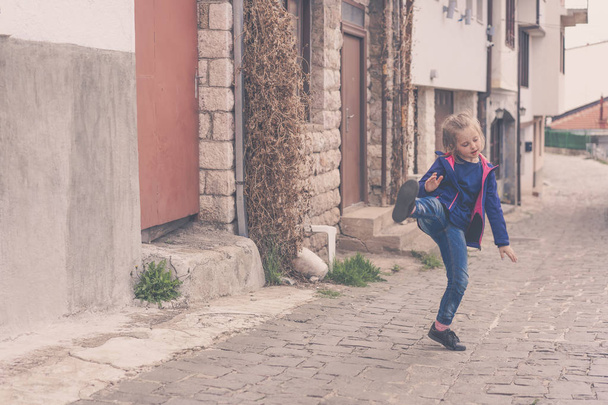 Little girl practising kicks on a street - 写真・画像