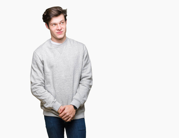 Csinos sportos fiatalember visel pulóver felső elszigetelt háttér mosolyogva látszó oldalon, és bámult el gondolkodás. - Fotó, kép