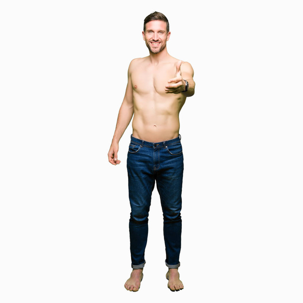 Komea paidaton mies osoittaa alasti rinnassa hymyilevä ystävällinen tarjoaa kädenpuristus kuin tervehdys ja kutsuva. Menestyksekäs yritys
. - Valokuva, kuva