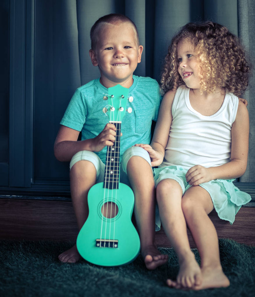 Portrait of a cute kids with ukulele - 写真・画像