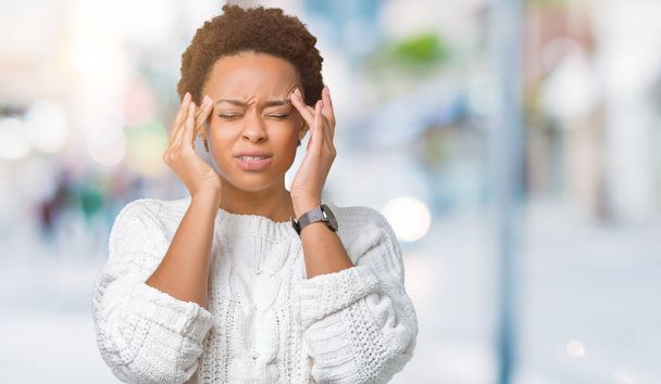 schöne junge afrikanisch-amerikanische Frau trägt Pullover über isoliertem Hintergrund mit der Hand auf dem Kopf für Kopfschmerzen wegen Stress. Migräne. - Foto, Bild