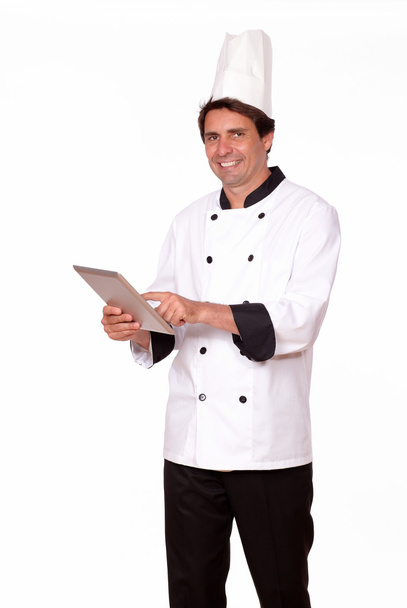 Professional male cook working on tablet pc - 写真・画像