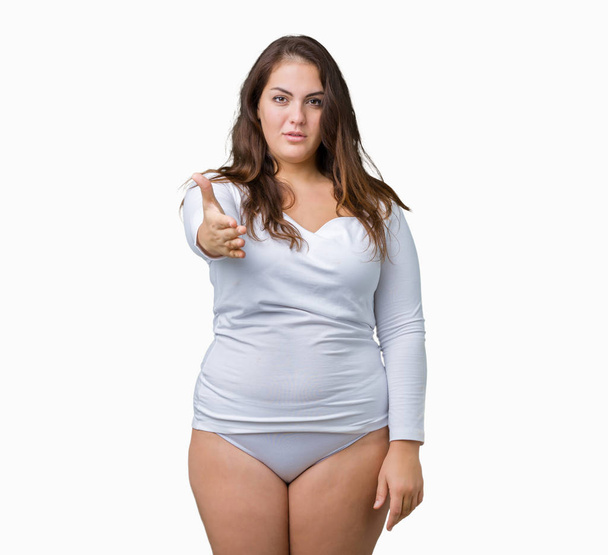 Beautiful plus size young overwight woman wearing white underwear over isolated background smiling friendly offering handshake as greeting and welcoming. Successful business. - Fotó, kép