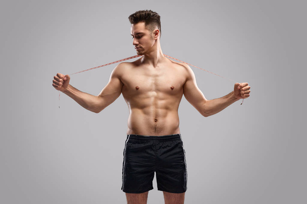 Shirtless sportsman with tape measure - Fotoğraf, Görsel
