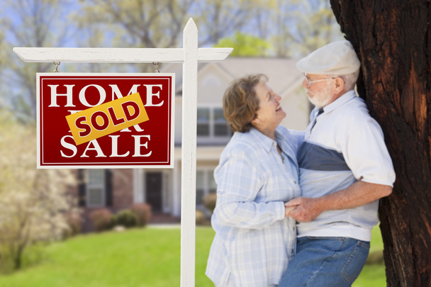 Immobilienschild mit Senioren-Paar vor Haus verkauft - Foto, Bild