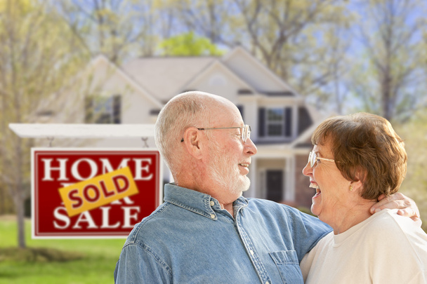 Senior Couple in Front of Sold Real Estate Sign and House - Foto, afbeelding