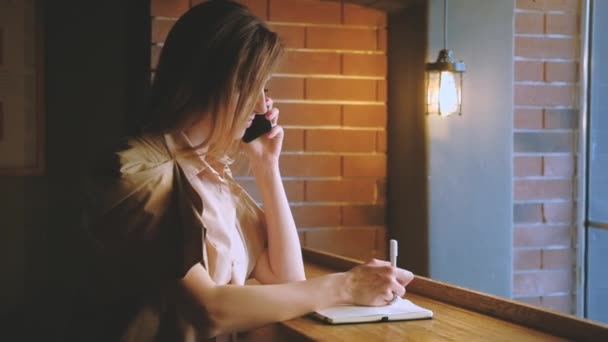 business communication woman taking phone notes - Кадры, видео