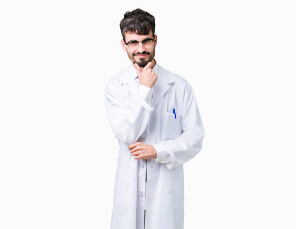 Young professional scientist man wearing white coat over isolated background looking confident at the camera with smile with crossed arms and hand raised on chin. Thinking positive. - Foto, immagini