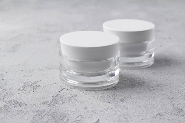 Two cosmetic jar containers at concrete background. Blank label  - Fotó, kép