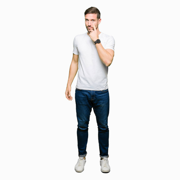 Hombre guapo vistiendo una camiseta blanca casual apuntando al ojo observándote gesto, expresión sospechosa
 - Foto, Imagen