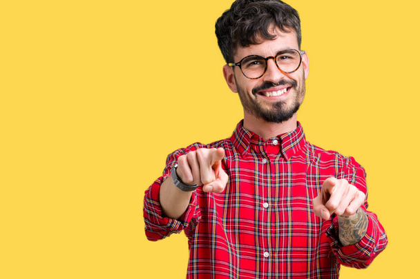 Jonge knappe man dragen bril over geïsoleerde achtergrond Pointing aan u en de camera met de vingers, positief en vrolijk lachend - Foto, afbeelding