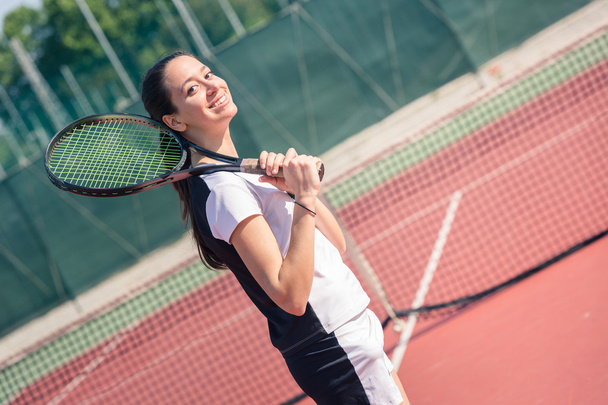 Young Woman Playing Tennis - 写真・画像