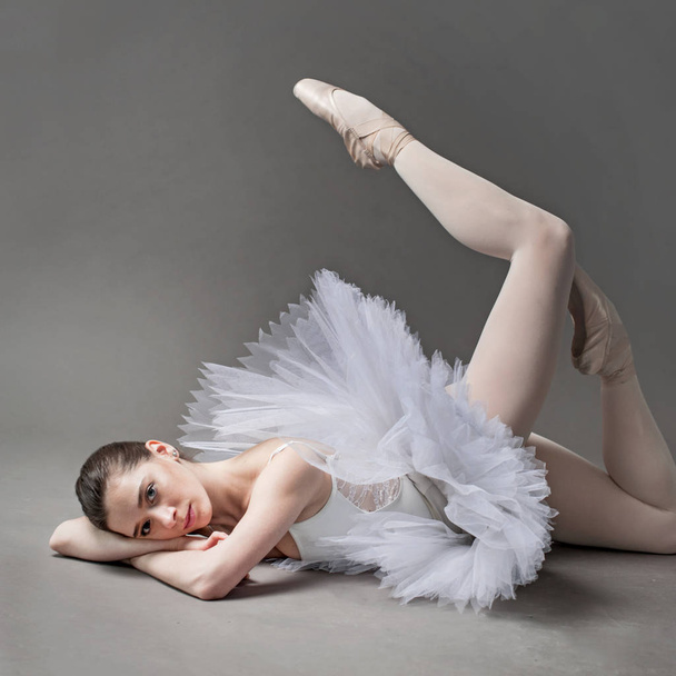 young ballerina on the floor of the studio lying down - Fotó, kép