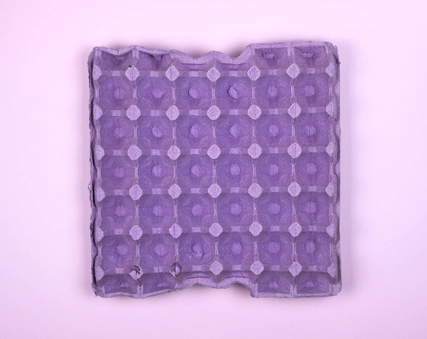 bandeja protectora púrpura para huevos de pollo crudos con células
 - Foto, Imagen