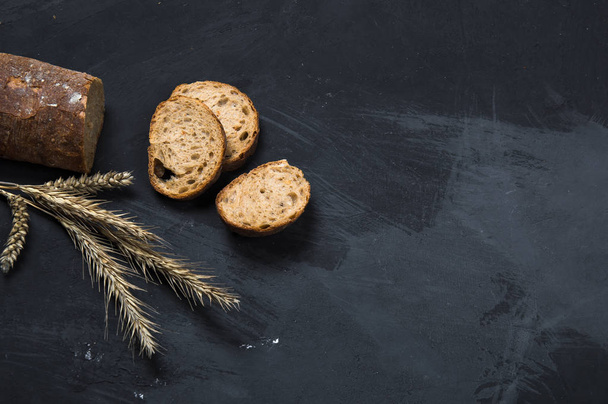 Freshly baked rye bread lies on a dark background. View from above - Foto, immagini