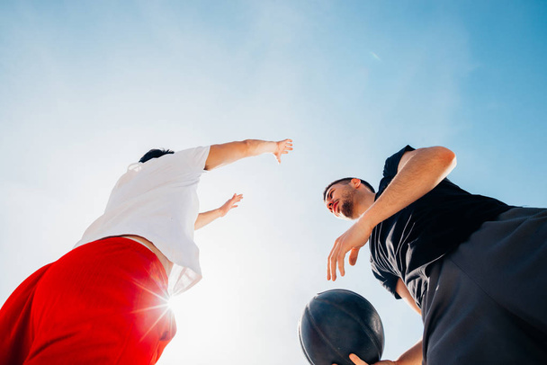 Δύο Καυκάσιοι μπασκετμπολίστες αγωνίζονται για κατοχή μπάλας  - Φωτογραφία, εικόνα