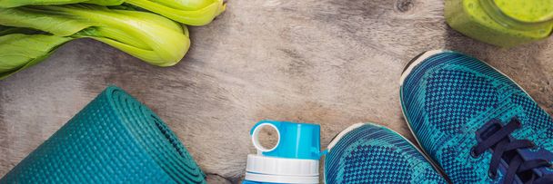 BANNER, LONG FORMAT Everything for sports turquoise, blue shades on a wooden background and spinach smoothies. Yoga mat, sport shoes sportswear and bottle of water. Concept healthy lifestyle, sport - Foto, Bild