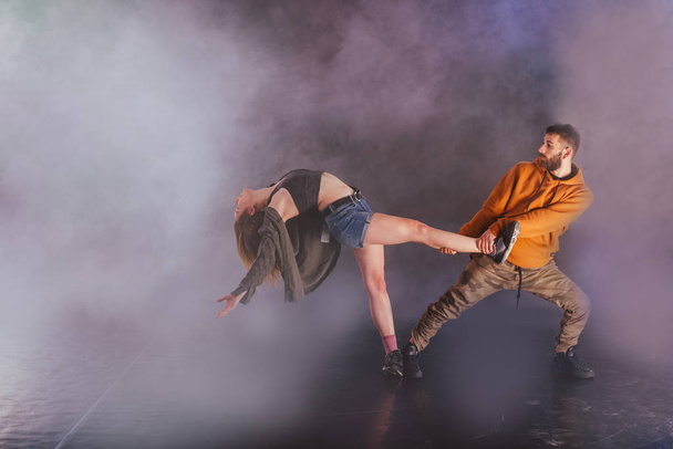Pari tanssii modernia tanssia ja keuliminen niiden jalka venyttää mo
 - Valokuva, kuva