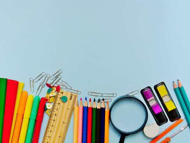 Colorful  school suplies against light blue background with copy space. Back to school concept, top view. - 写真・画像