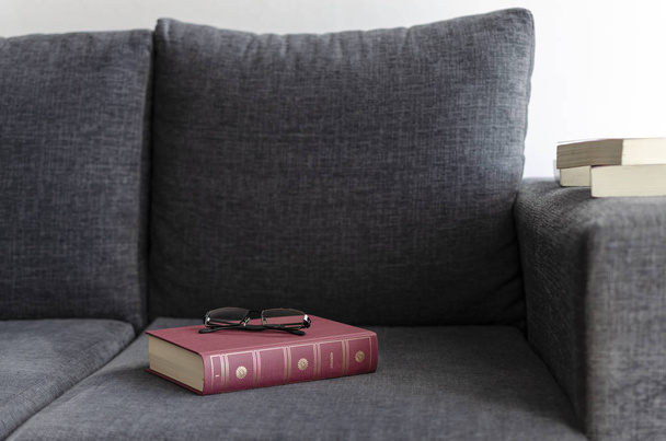 books on the sofa. armchair. glasses. - Zdjęcie, obraz