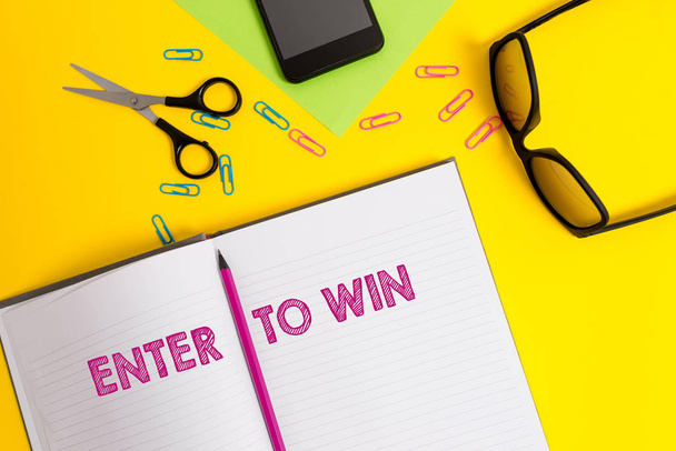 Word writing text Enter To Win. Business concept for exchanging something value for prize or chance of winning Sheet pencil clips smartphone scissors eyeglasses notepad color background. - Photo, Image