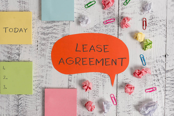Word writing text Lease Agreement. Business concept for Contract on the terms to one party agrees rent property Blank speech bubble paper balls clips sticky notes old wooden background. - Photo, Image