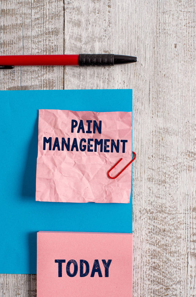 Word writing text Pain Management. Business concept for a branch of medicine employing an interdisciplinary approach Wrinkle paper and cardboard plus stationary placed above wooden background. - Photo, Image