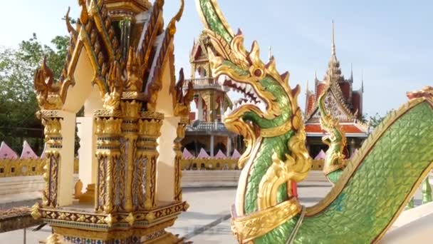 Зеленый дракон во дворе восточного храма. Зеленая статуя дракона, расположенная во дворе традиционной азиатской святыни в солнечный день. Ват Плай Лаем. Самуи
. - Кадры, видео