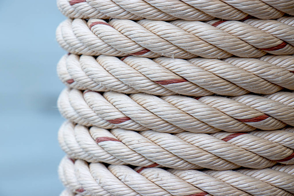 detail of white ship rope wrapped around the pole at fishing port, pattern background - Fotó, kép
