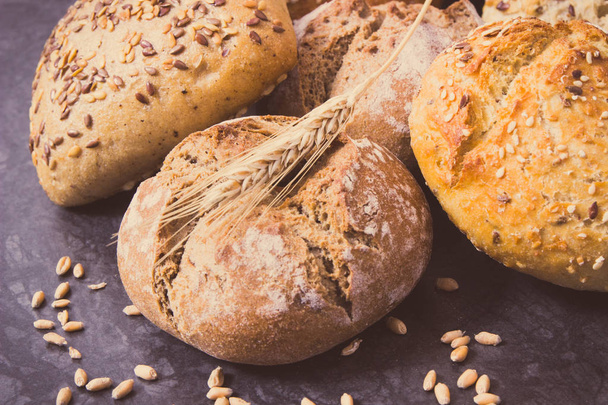 Fresh baked rolls with seeds and ears of rye or wheat grain. Vintage photo - Φωτογραφία, εικόνα