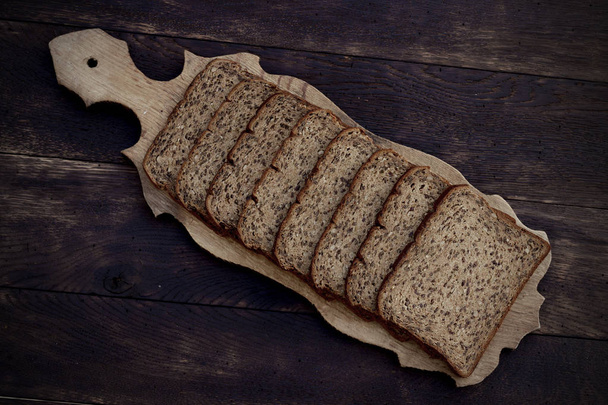 Bread slices on wooden oak table - Fotografie, Obrázek