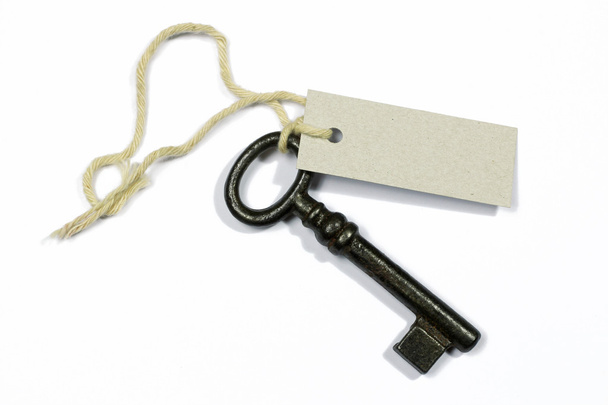 alter Schlüssel mit leerem Etikett auf weißem Hintergrund - Foto, Bild