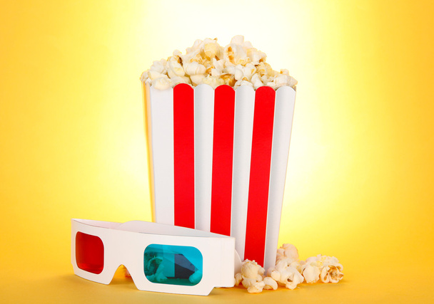 Popcorn and 3D glasses on yellow background - Foto, Imagen