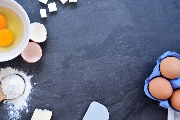 Bach utensils on a kitchen plate - eggs, flour, butter and sugar - Concept with place for text  - 写真・画像