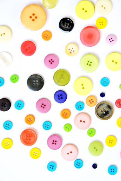 Duży zestaw przycisków w różnych kolorach i wzorach przed jednym kolorowym tłem  - Zdjęcie, obraz