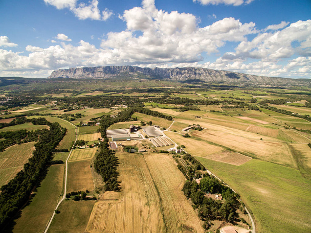 フランス南部の大きな農場を持つ農場の航空写真。山の隣の夏の乾季の間に大きな農地. - 写真・画像