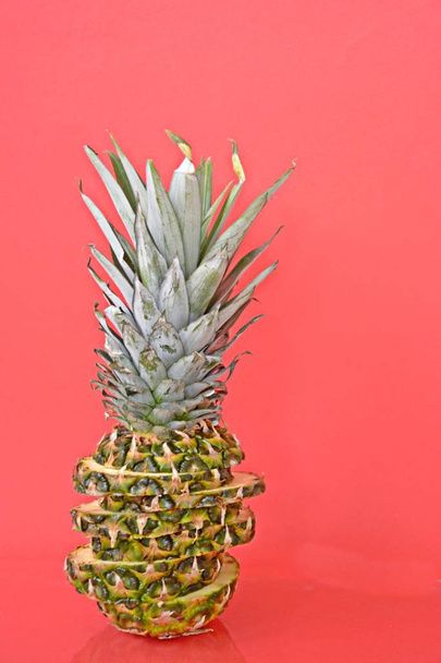 slices of a pineapple make up a whole pineapple in front of a solid background with space for text or objects - Fotó, kép