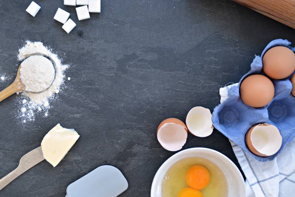 Σκεύη Bach σε πιάτο κουζίνας-αυγά, αλεύρι, βούτυρο και ζάχαρη-έννοια με θέση για κείμενο  - Φωτογραφία, εικόνα