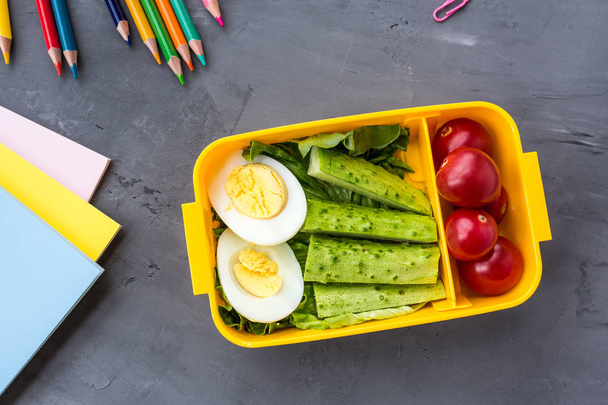 School supplies and lunch box with sandwich and vegetables. Back to school. Healthy eating habits concept - background layout with free text space. Flat lay composition, mockup, top view - Φωτογραφία, εικόνα