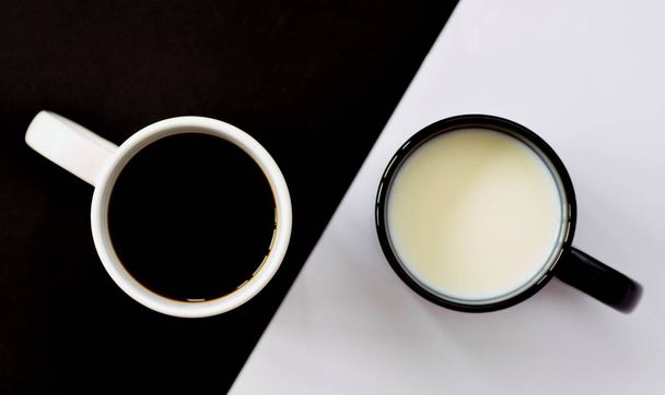Dva šálky před půldruhým černým a polovičním bílým pozadím, jeden šálek obsahuje kávu, druhé mléko a obojí, koncept pro Yin a Yang s kávovou šálkem - Fotografie, Obrázek
