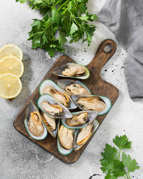 Kiwi mussels on a wooden Board on a gray background. Healthy diet - Photo, Image