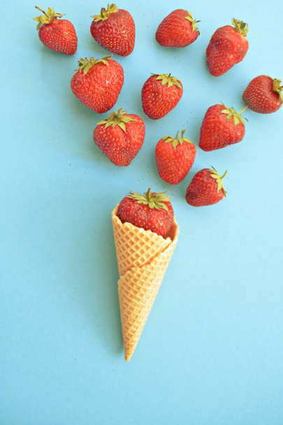 Roomijs kegel met aardbeien op een gekleurde achtergrond - Foto, afbeelding