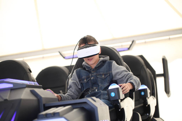 Belarus, Minsk, june 2019 .  Child with glasses  virtual reality game simulator - Foto, afbeelding