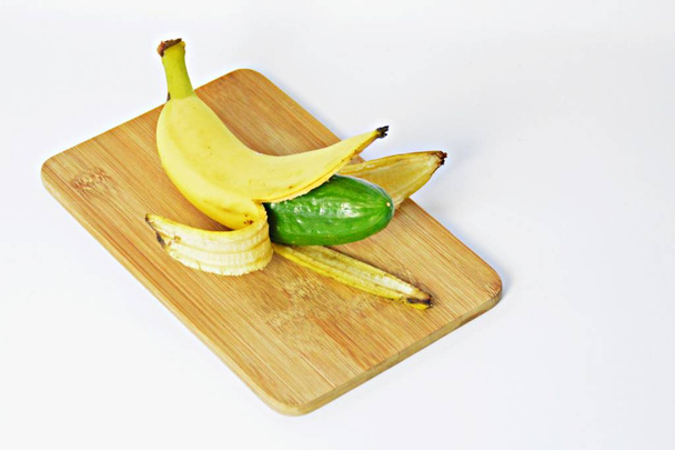 Een komkommer in de schil van een banaan - Foto, afbeelding